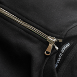 Arthur Raymond men's quarter zip bomber sweater in black, close up of front showing the chunky silver zip and black and white Arthur Raymond clothing neck tag, on grey background